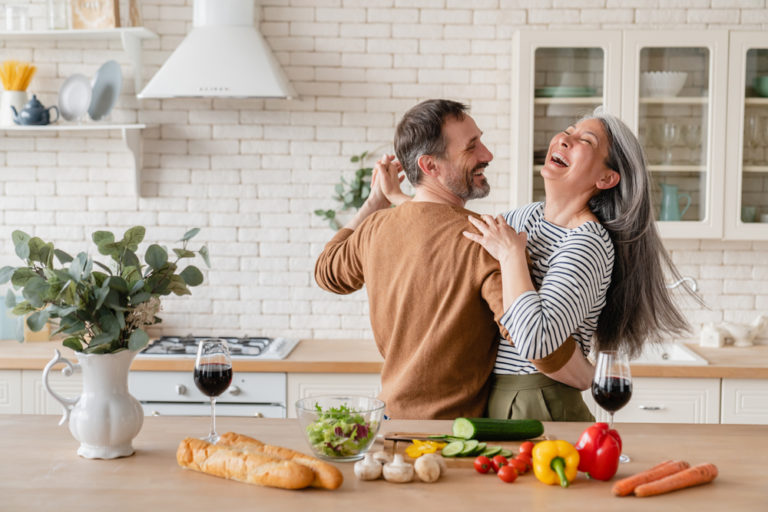 healthy middle aged couple laughing in kitchen